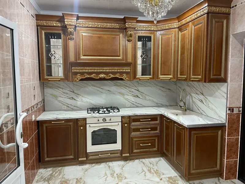 Угловая кухня цвета ореха с золотой резьбой и мраморным фартуком
